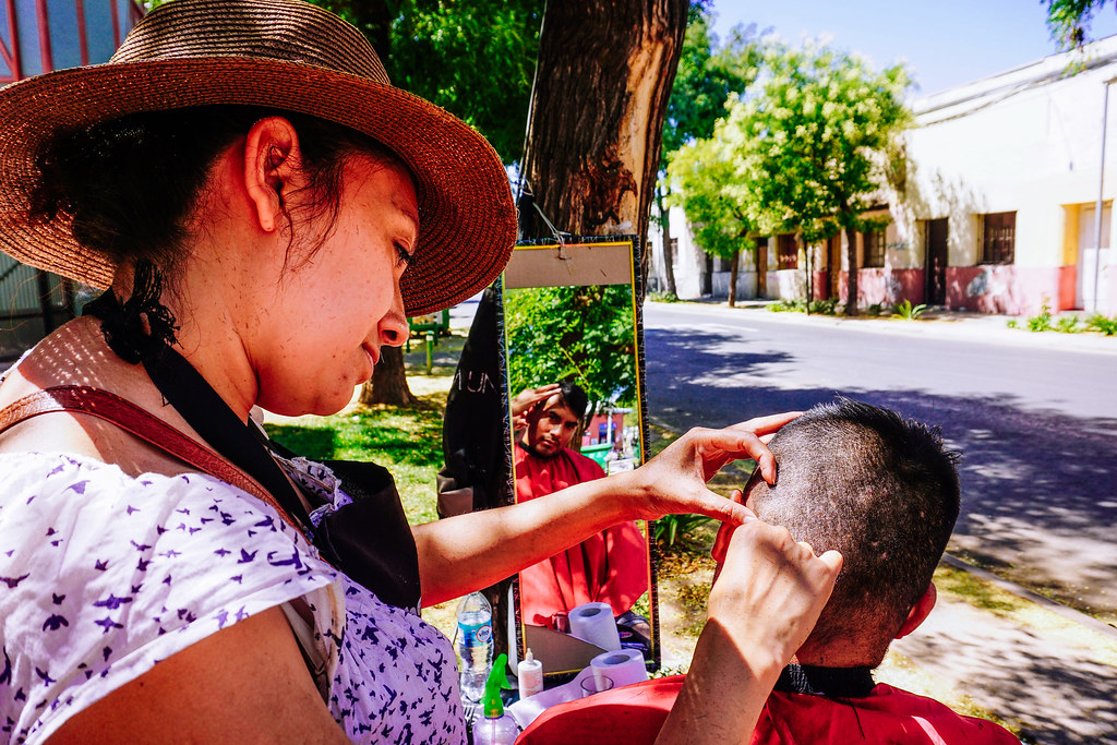 Barbero trabajando en una acera de la ciudad
